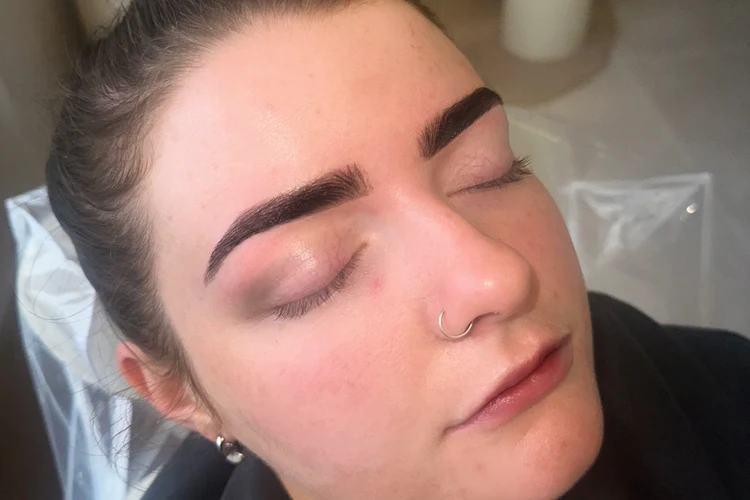 Close-up of tinted and shaped eyebrows on a relaxed client