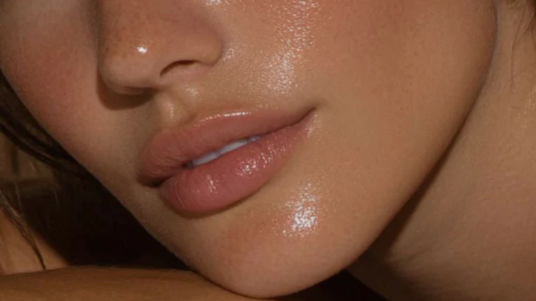 Close-up of glossy lips with a soft natural pink tint after lip blush treatment
